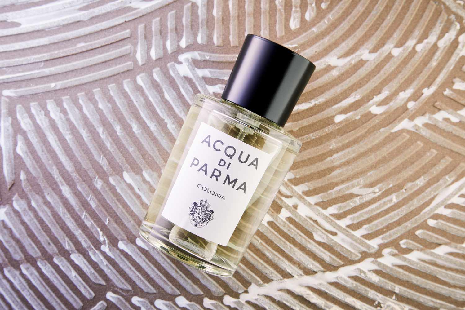 The Acqua di Parma Colonia bottle on a textured background